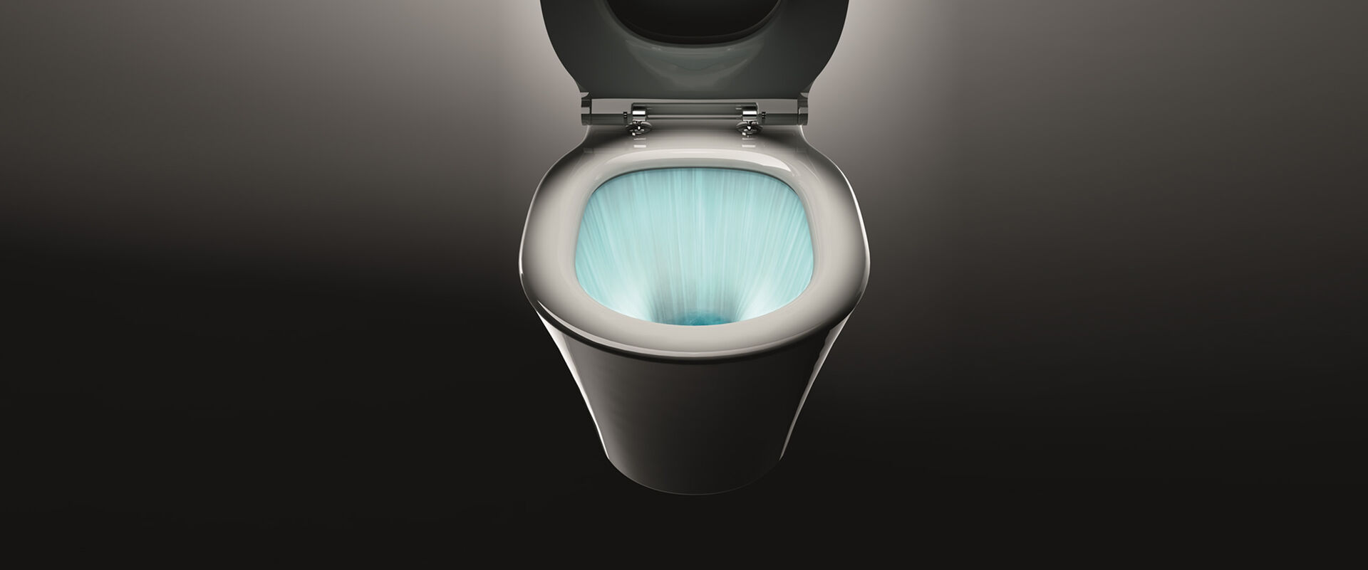 Magische Aufnahme eines geöffneten WCs vor einem schwarzen Hintergrund. Man sieht in das WC-Becken, wo dank AquaBlade Spültechnik Ideal Standard leuchtend eingefärbtes Wasser das komplette WC ausspült.