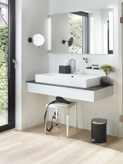 Hotel-Waschbereich mit Kosmetikspiegel, Hocker, Fön und einem großzügigen Lichtspiegel der Serie Smartline von SPRINZ