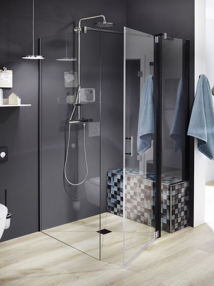 Moderne Duschkabine mit Duschsystem und einer befliesten Sitzbank.