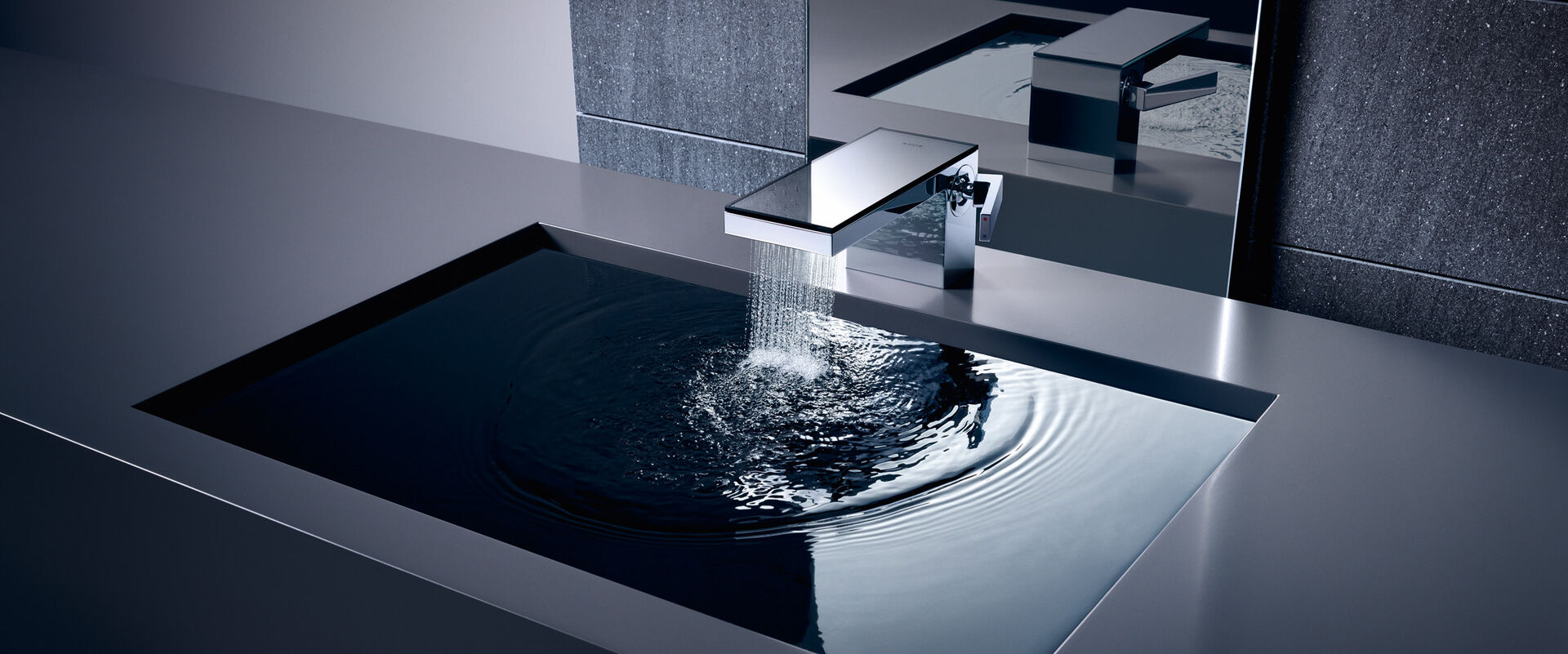 Design Badarmatur aus Chrom mit Wasserstrahl. Waschbecken mit gefülltem Wasser.