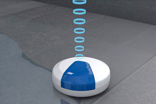 Der runde Sensor SafeFloor von SYR wird einfach auf dem Boden platziert und erkennt auftretende Feuchtigkeit. Im Notfall wird so per Funk ein Alarm ausgelöst.
