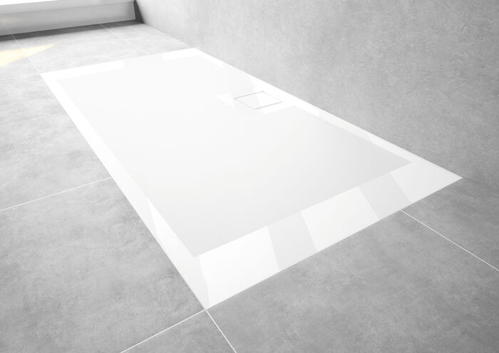 Weiße EasyFlat Duschfläche von HUEPPE, die in einem grau gefliestem Boden eingelassen ist.