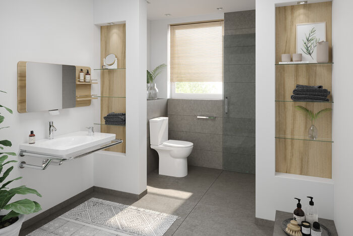 Die moderne, barrierefreie Badgestaltung von VitrA Conforma beinhaltet einen großzügigen Waschtisch mit raumsparendem Siphon installiert, so dass man davor sitzen kann, ein Stand-WC, Dusche und praktische Regalwände in hellem Holz mit Glasböden.