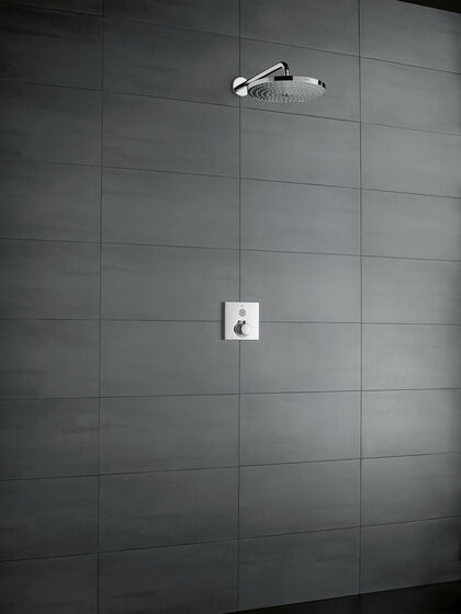 Grau geflieste Duschwand, an der ein rechteckiges hansgrohe ShowerSelect Thermostat befestigt ist. Darüber befindet sich eine Kopfbrause.