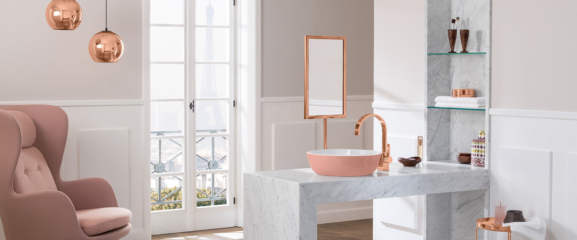 Helles Badezimmer mit rosafarbenen Elementen und Waschbecken Artis von Villeroy und Boch. Das Waschbecken steht auf einem steinernen Waschtisch, daneben befindet sich ein Regal. Links steht ein großer, rosaner Sessel.