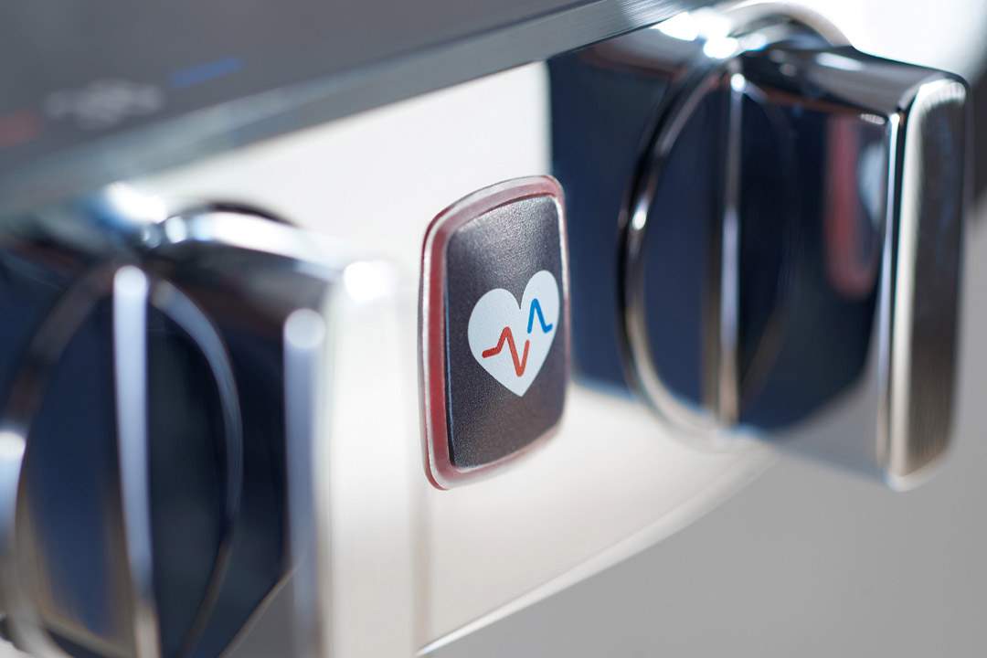 Betätigungsknopf der Duscharmatur Wellfit von Hansa. Auf dem Knopf ist ein Herz als Logo dargestellt.
