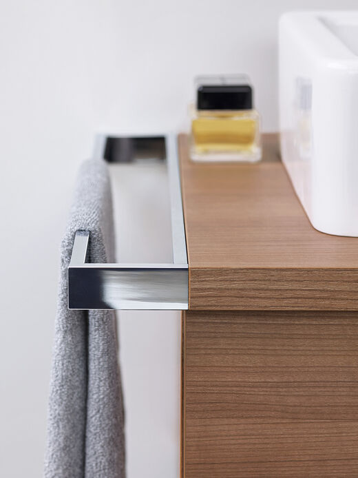 Duravit Vero Detailaufnahem Handtuchreeling chromfarben an Badmöbel aus Holz.