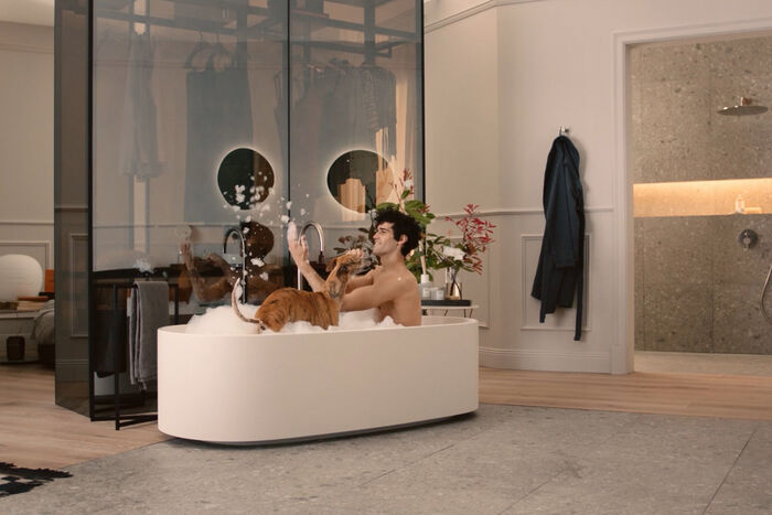 Mann und Hund baden in der eleganten und filigran gestalteten Badewanne aus der Kollektion Linda-X von Ideal Standart 