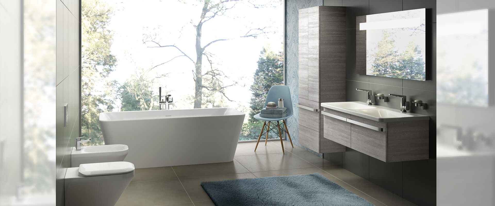 Badambiente mit freistehender Badewanne vor großem Fenster. Doppelwaschbecken und Badmöbeln aus Holz.