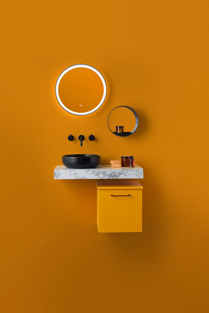 Orange Waschtischkombi, bestehend aus Unterschrank, Waschtisch, der dann der Wand montiert ist, Aufsatzwaschbecken und Armaturen in schwarz sowie Spiegeln an der Wand.