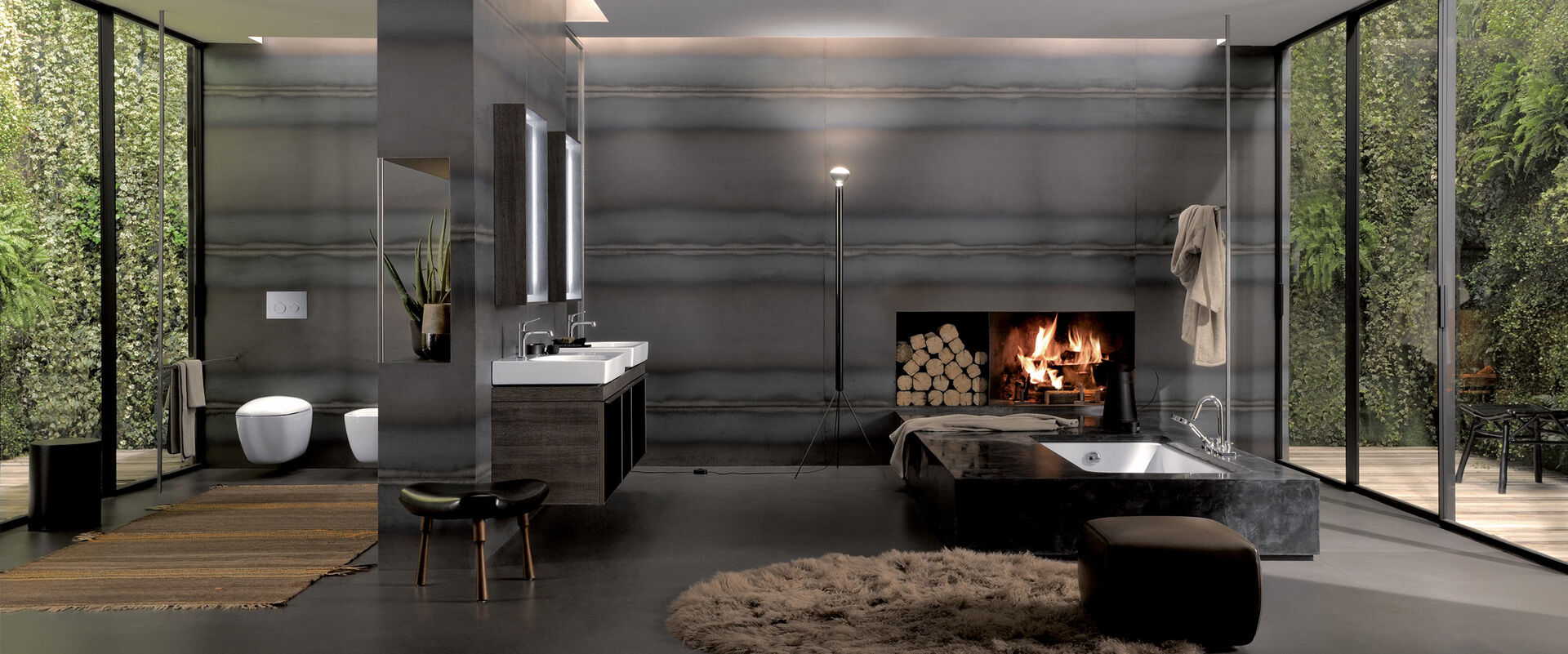 Geberit Citterio Komplettes Badezimmer mit braunen Badmöbeln und einem angezündeten Kamin. Badmöbel seitlich, Spiegelschrank, Badewanne. Bidet und WC.