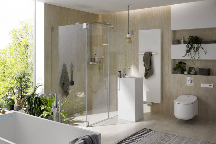 Modernes Bad renoviert mit weisser Badkeramik. Freistehende Badewanne, begehbare dusche, WaschtischsÄule und Badheizkörper.