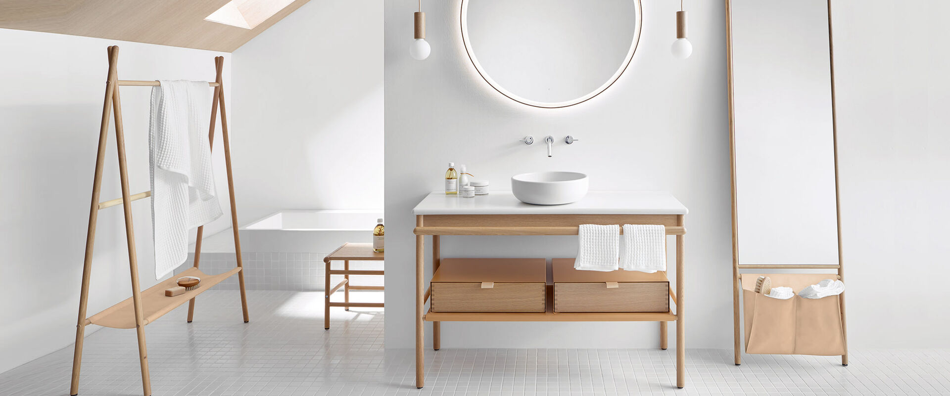 Designer Badezimmereinrichtung von burgbad aus der Serie Mya. Helles Naturholz und klassische Stelzenfüße charakterisieren diese Badmöbel. 