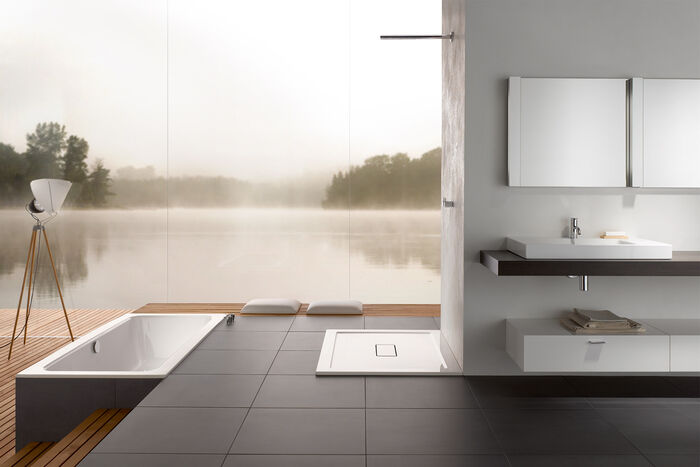 Design Badezimmer weiss mit Landschaft im Hintergrund. Badewanne, Duschfläche und Waschbecken von Betteone.