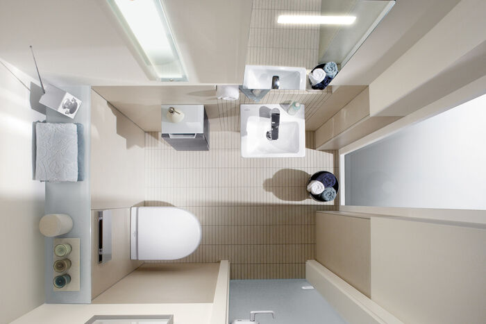 Helles Gästebad von oben fotografiert. Kleines Waschbecken, seitlicher kleiner Wandschrank und eine Toilette.