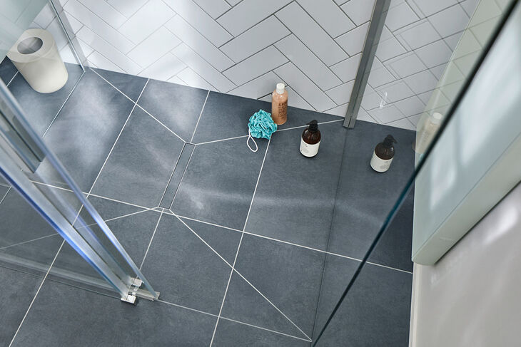Kermi Line Bodenebener Duschplatz LINE von Kermi komplett verfliest – Blick von oben in die Dusche.
