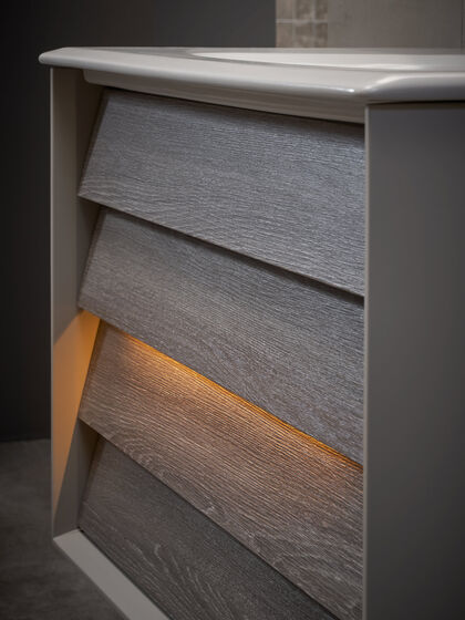 Detail Waschbeckenunterschrank Badmöbel mit Beleuchtung der Lamellenschublade.