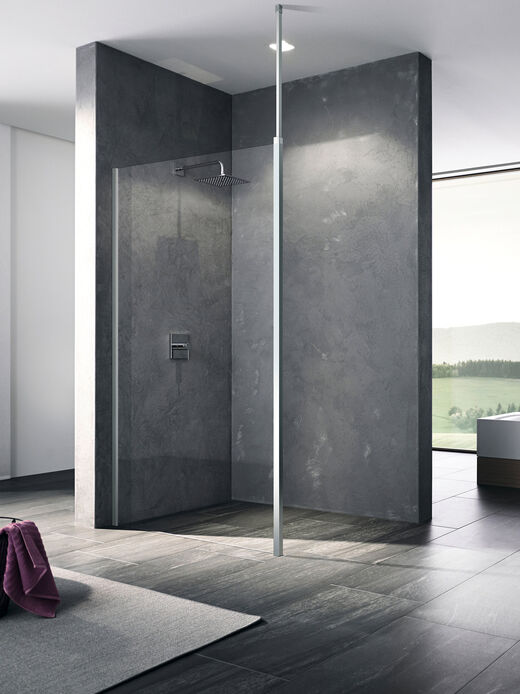 Bodenebene Dusche, an der eine Kermi Walk In XB Wall installiert ist. Die Duschwand aus Glas trennt die Dusche vom restlichen Badezimmerraum, dessen Boden in Holzoptik gestaltet ist.