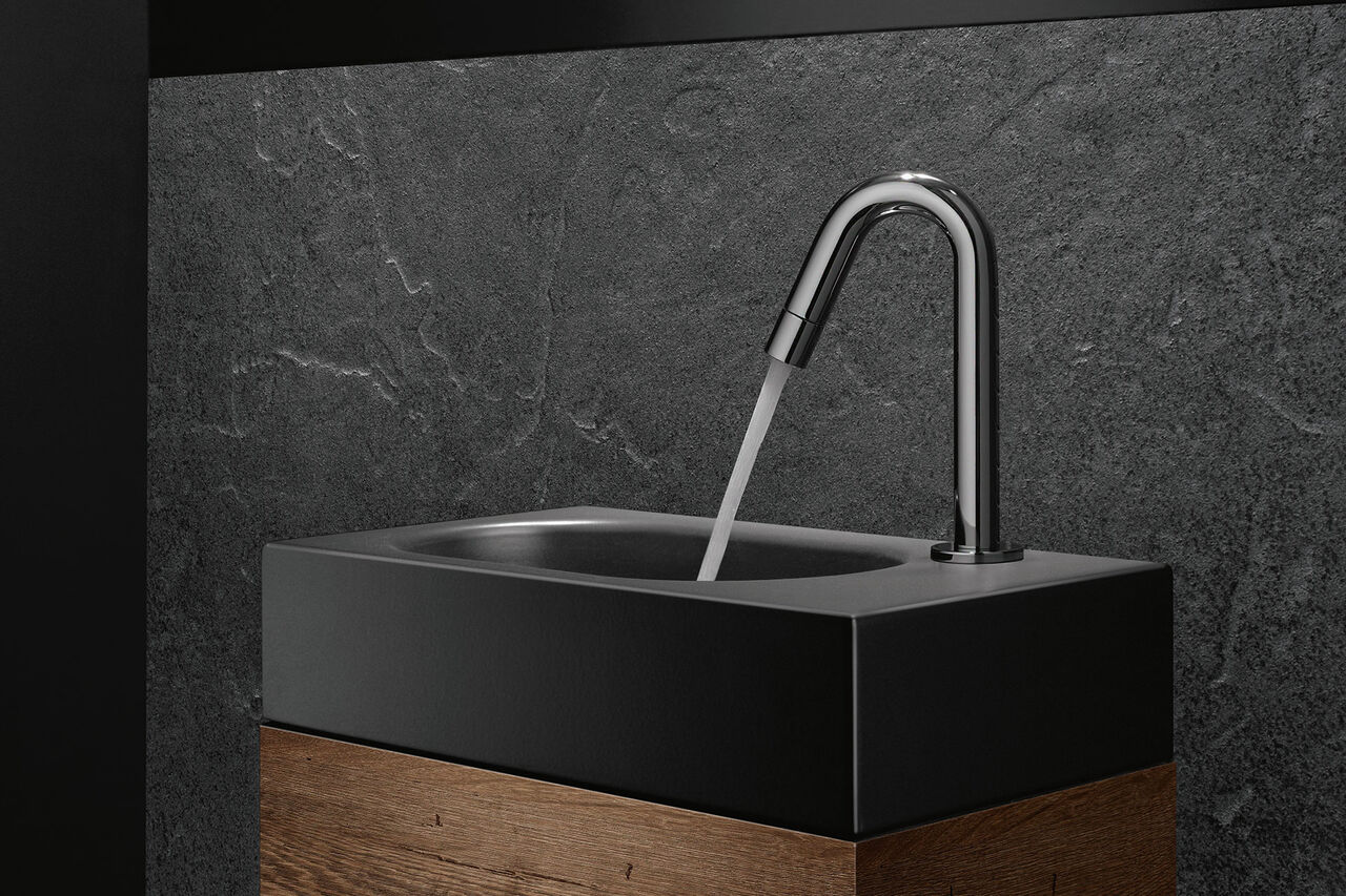 Armatur pur: die gebogene Waschbecken-Armatur von Kludi Bozz kommt ohne Bedienhebel aus. Man bedient das Wasser über einen Drehregler im Auslauf integriert.