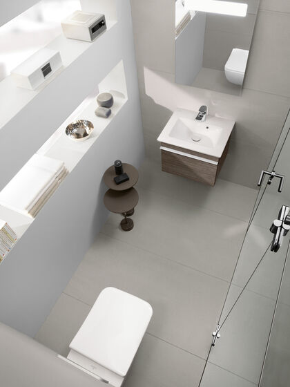 Ansicht von oben auf komplettes kleines Badezimmer mit Toilette, Waschbecken mit Badmöbel und Spiegel