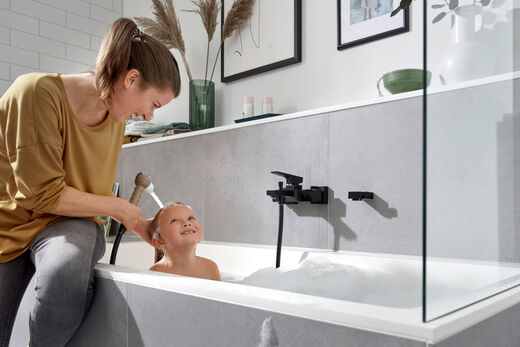 Mutter wäscht Kind das Shampoo problemlos aus mit der Jocolino Kinderbrause von hansgrohe