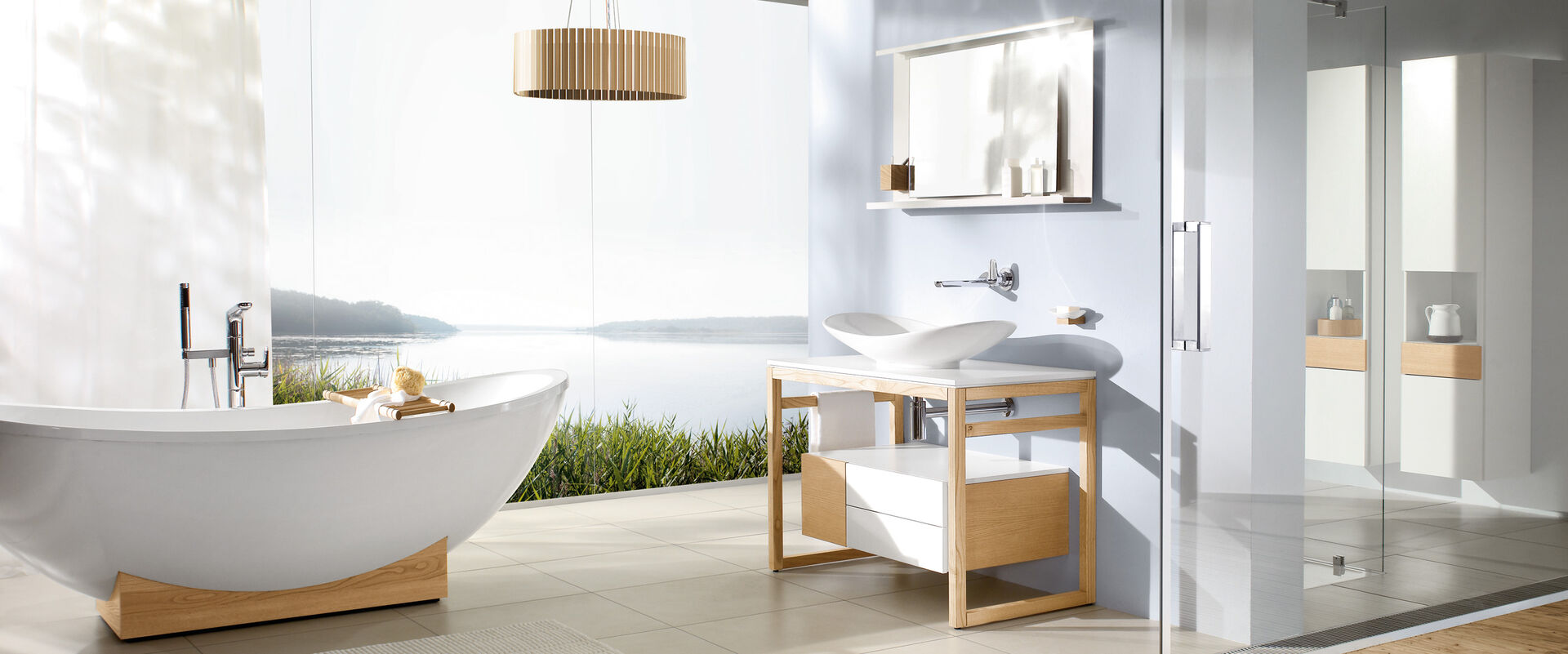 Modernes Bad mit Badmöbeln aus Holz und weiß. Badewanne auf Holzsockel freistehend. Blick nach draussen.