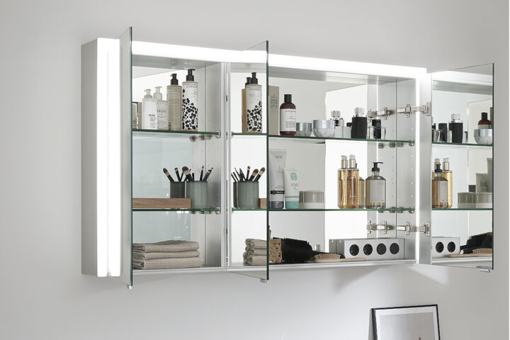 Spiegelschrank Elegant-Line 2.0 von SPRINZ mit dreiseitiger LED-Beleuchtung, geöffneten Spiegeltüren und einer verspiegelten Innenwand.