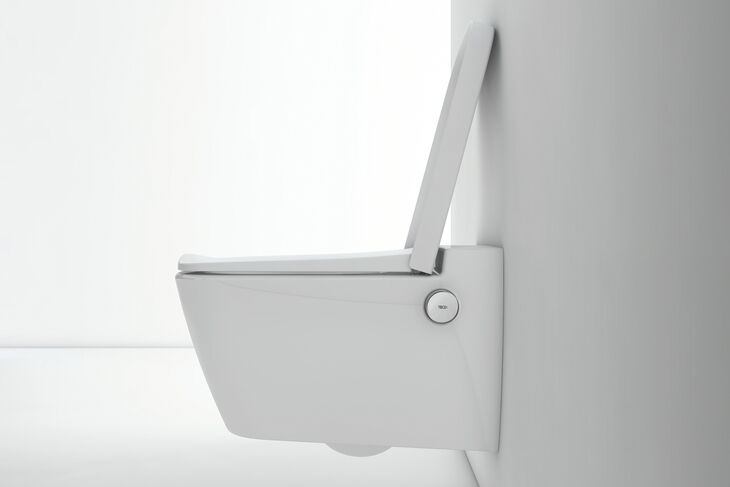 Seitenansicht eines TECE Dusch-WCs mit aufgeklapptem Deckel. Unterhalb des Deckels ist der Drehkopf zur Bedienung integriert.