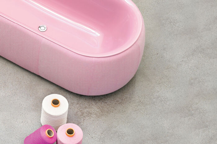 Bette Oval Couture Badewanne von Bette in rosa, die auf einem Betonboden steht und von oben fotografiert wurde.