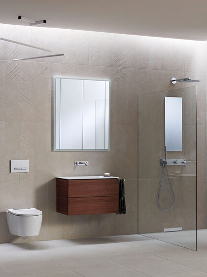 Ausschnitt eines Geberit Bades, das mit den aktuellen ONE Produkten ausgestattet wurde: WC, Waschplatz mit Waschbeckenunterschrank, Spiegelschrank und moderne Duschabtrennung ohne sichtbare Profile.