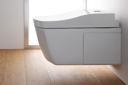 TOTO Europe Washlets An der Wand hängend montiertes Dusch-WC von TOTO aus der modernen Serie Neorest. Kompaktes Design und klare Formensprache. Seitenansicht mit Holzboden.