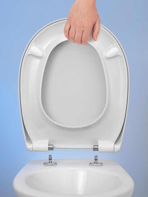 Zur Reinigung einfach mit der Hand abnehmen – dank der TakeOff® Scharniere können WC-Sitze von HARO Hamberger einfach von der Toilette abgelöst werden. So sind sonst unzugängliche Stellen fix gewischt. 