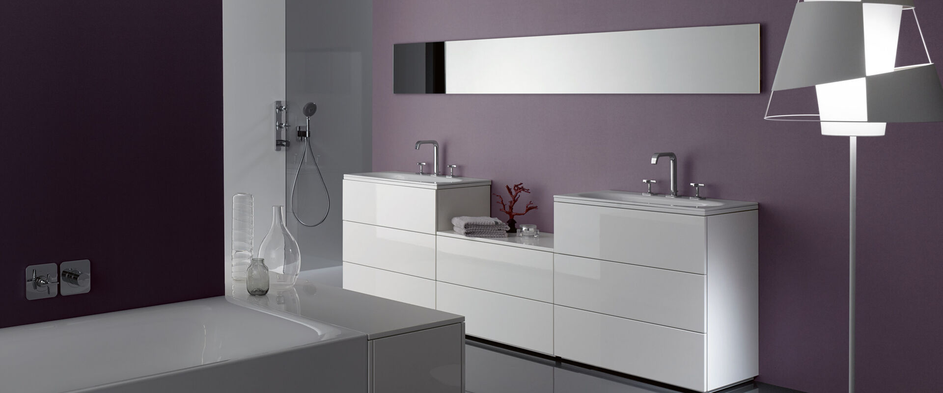 Weißes Sideboard für das Bad mit Staufächern und Auszügen vor einer violetten Wand.