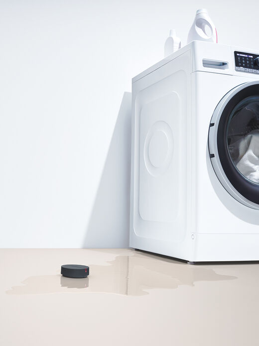 hansgrohe Pontos Scout Leckageschutz Pontos Scout in Wasserpfütze neben Waschmaschine.