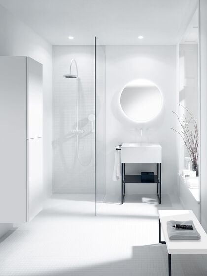 Modernes Bad mit begehbarer Dusche und filigranen Badmöbeln in Weiß. Sitzbank, Waschbecken in Stahlgestell und runder Spiegel.