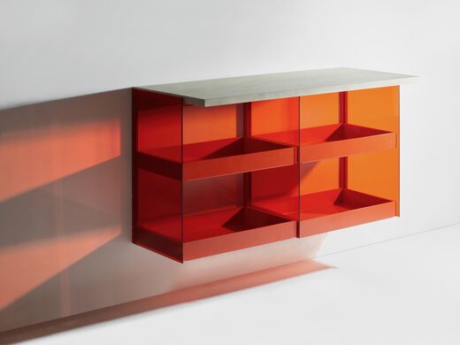 Transparentes, freihängendes Badezimmermöbel aus rotem Glas mit Schubladen und Regalflächen. 