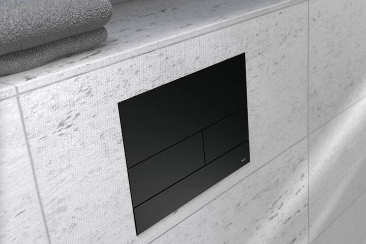 Schwarz veredelte Toiletten-Drückerplatte von TECEsquare2 mit Zweimengen-Technologie.