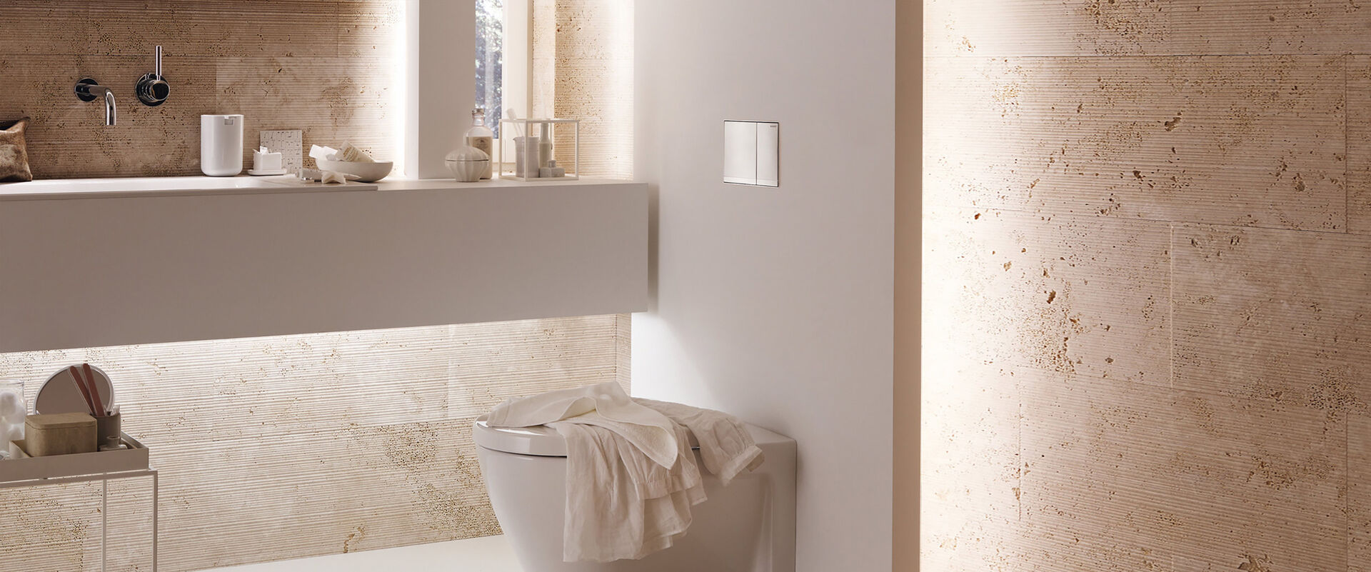 Fokus auf den WC-Bereich eines in warmen Farben beleuchteten Badezimmers von Geberit. Das WC wurde mit einer Sigma 60 Drückerplatte versehen.