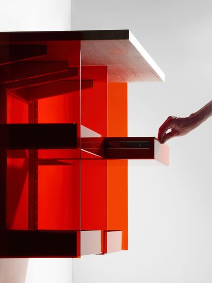 Transparentes Badezimmermöbel aus rotem Glas mit ausziehbaren Schubladen und Ablagefläche.