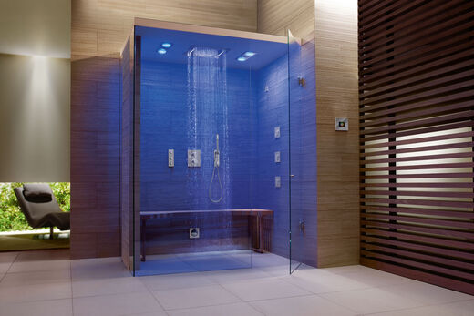 GROHE Spa F-digital Deluxe Dampfdusche im Badezimmer. Beleuchtet in Blau mit runder Deckendusche und seitlichen Massagedüsen.