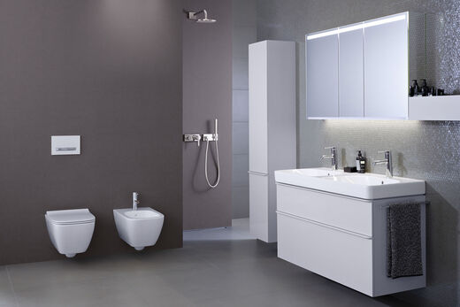 Ausgewogenes Designbadezimmer Smyle von Geberit mit WC/Bidet, Dusche und Waschplatz. Das WC trägt einen extraschlanken Slim-WC-Sitz.