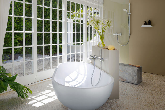 Ovale Badewanne mit Wannenarmatur an der Wand montiert im Badmilieu.