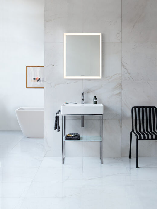 Duravit DuraSquare Waschbecken im Stahlgestell. Seitlicher Handtuchhalter und einem beleuchteten Spiegel darüber.