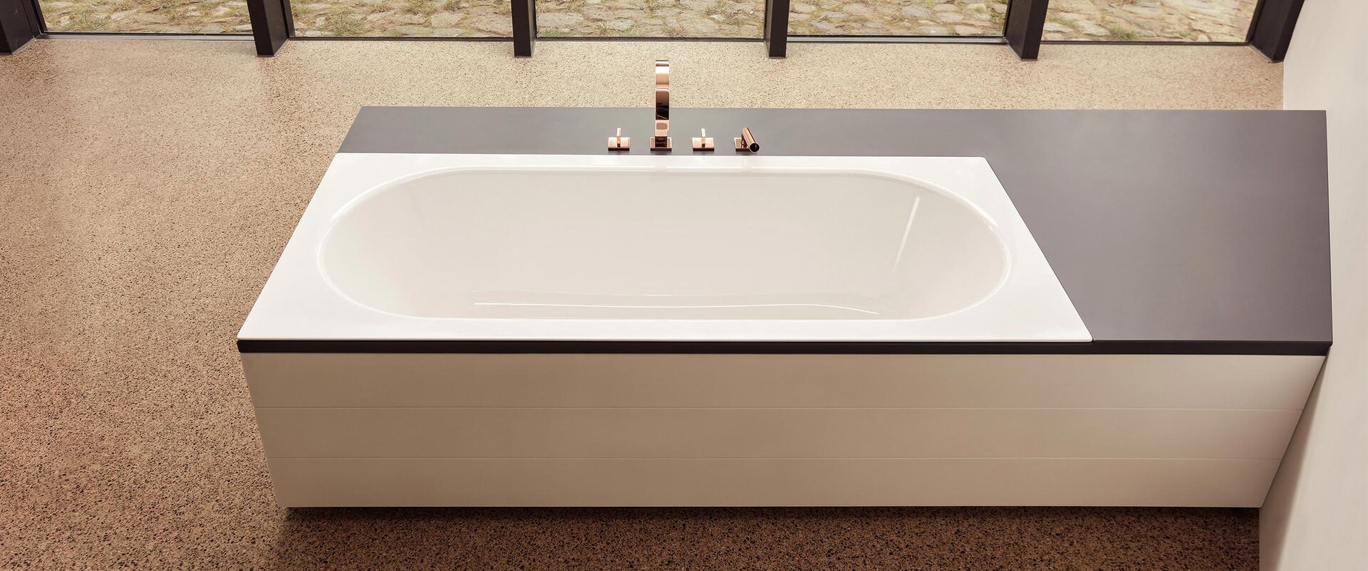 Badewanne weiss eingebaut mit 3-Loch Badewannenarmatur in Kupfer.