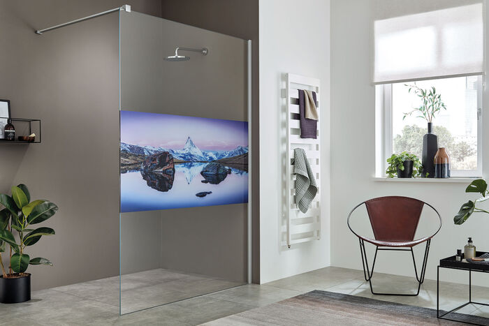 Hochwertiges Sicherheitsglas und robuste Beschlagstechnik machen das Duschvergnügen in der frei begehbaren Dusche ColorStar von Sprinz sorglos und sicher. Glaswand mit Motiv Matterhorn bedruckt.
