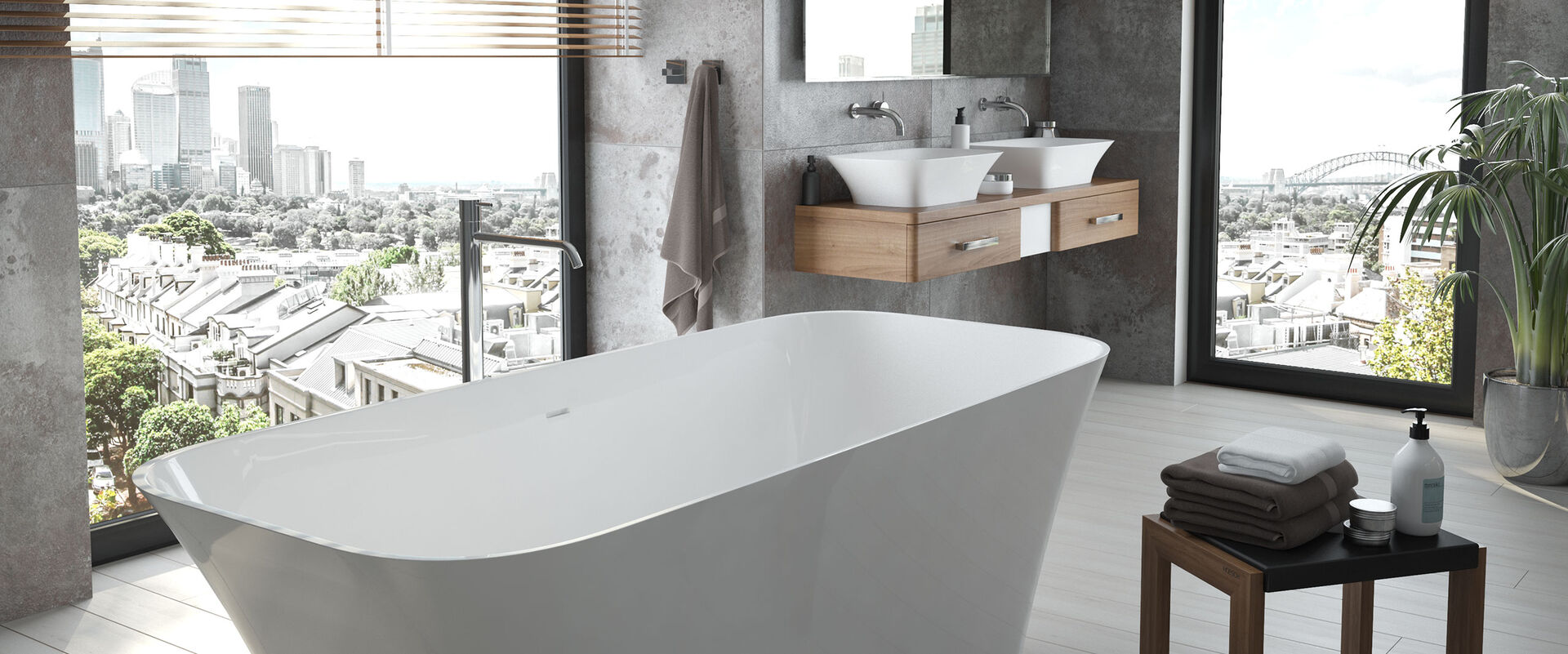 Badezimmer mit Fensteraussicht von Hoesch, das mit einer eleganten und großzügigen Freistehwanne und den Waschbecken aus der Serie Leros ausgetattet ist. Beide Produkte sind aus Solique Mineralguss gefertigt.
