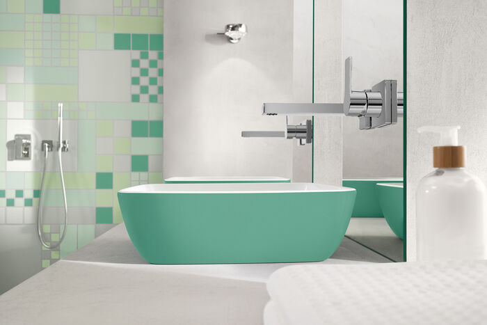 Grünes Waschbecken Artis von Villeroy und Boch, das sich auf einem grauen Waschtisch befindet. Darüber hängt ein Spiegel. 