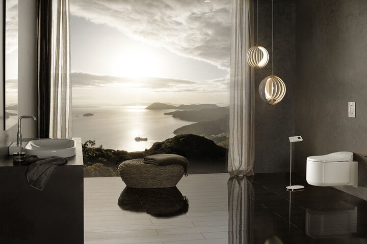 Stimmungsvolles Badezimmer mit Waschplatz und Dusch-WC Sensia Arena von Grohe. Ein großes Fenster mit Blick auf Meer und Inseln lässt das Abendlicht in den Raum.