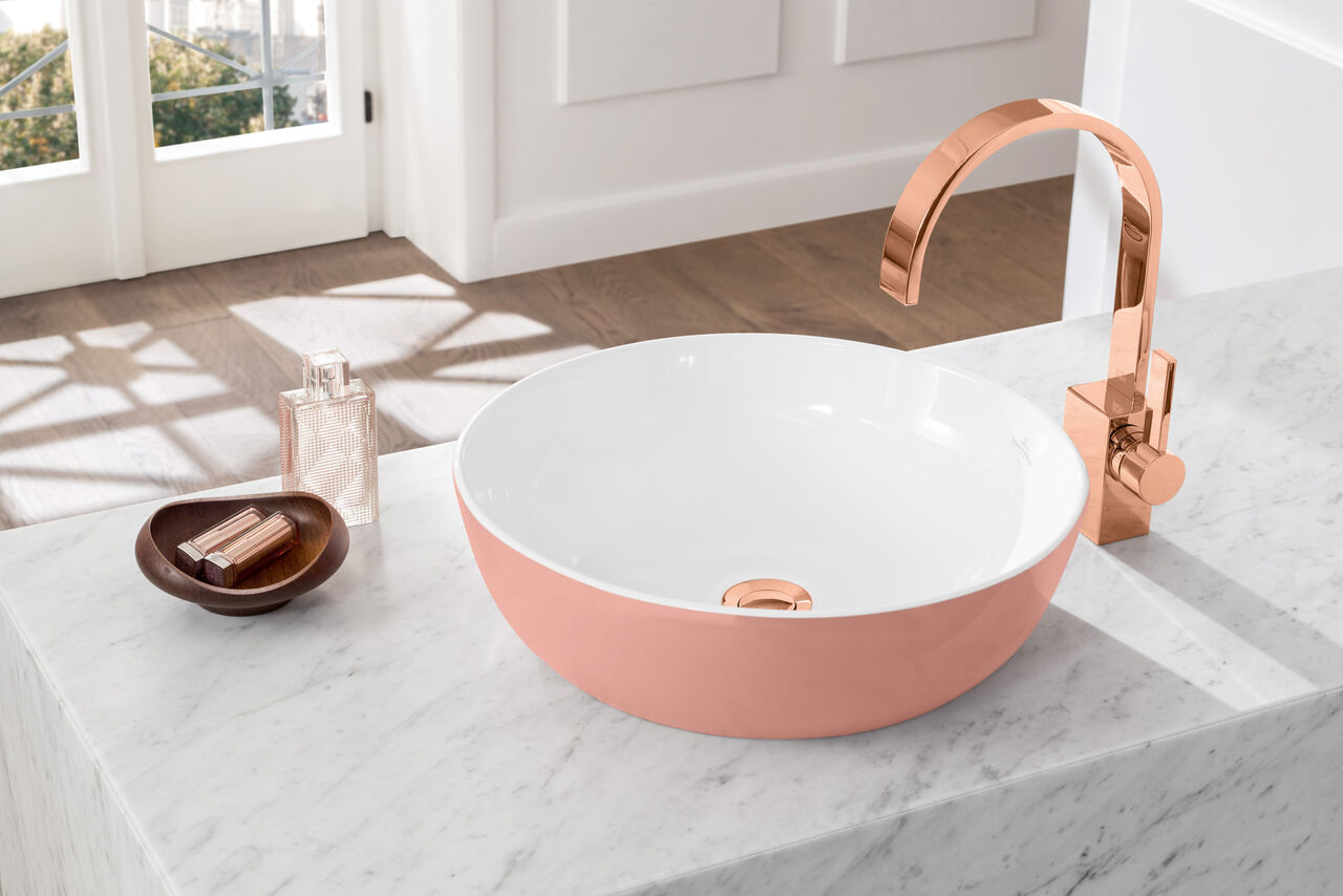Waschbecken Artis von Villeroy & Boch Rosa Waschbecken Artis von Villeroy und Boch, neben dem ein rosafarbener Wasserhahn installiert ist.