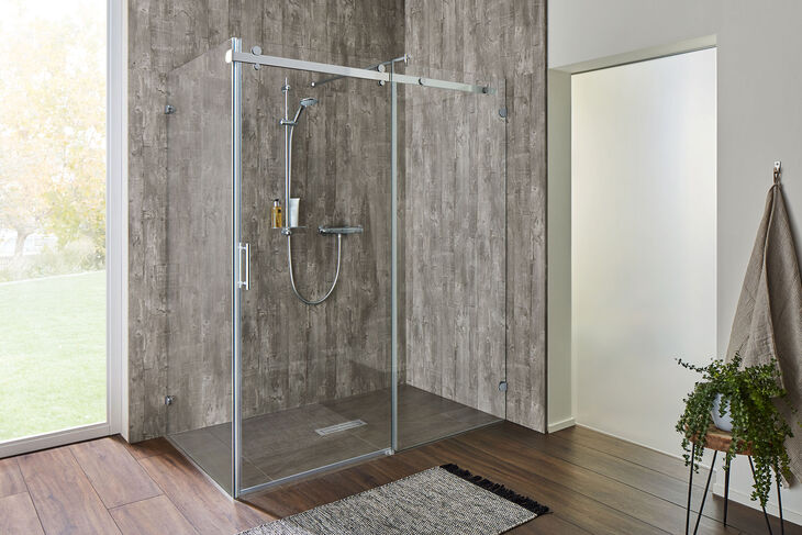 Moderner Duschbereich mit grauen Holzfliesen und begehbarer Dusche Opalin S von SPRINZ. Eine fixe Glaswand trifft auf eine Gleittür-Konstruktion, die die Glastür sanft zur Seite rollen lässt.